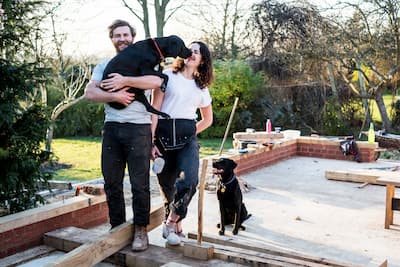 smiling-man-and-women-and-two-black-dogs-on-buildi-2025-04-04-08-31-44-utc (1) (1).jpg