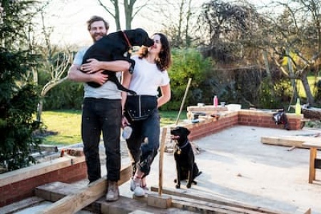 smiling-man-and-women-and-two-black-dogs-on-buildi-2025-04-04-08-31-44-utc (1) (1).jpg